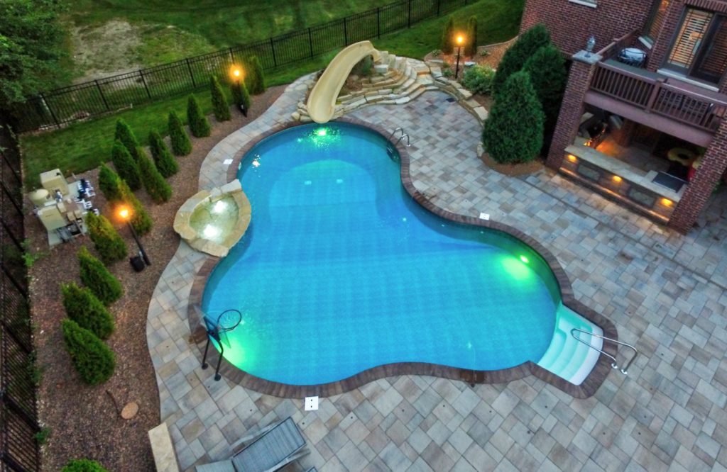 Pool is a hot tub with stereo system wrapped in brick & topped with Travertine