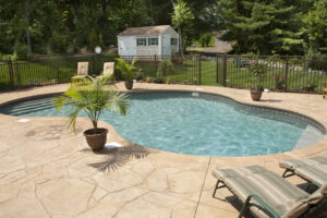 Lush backyard swimming pool and patio space.